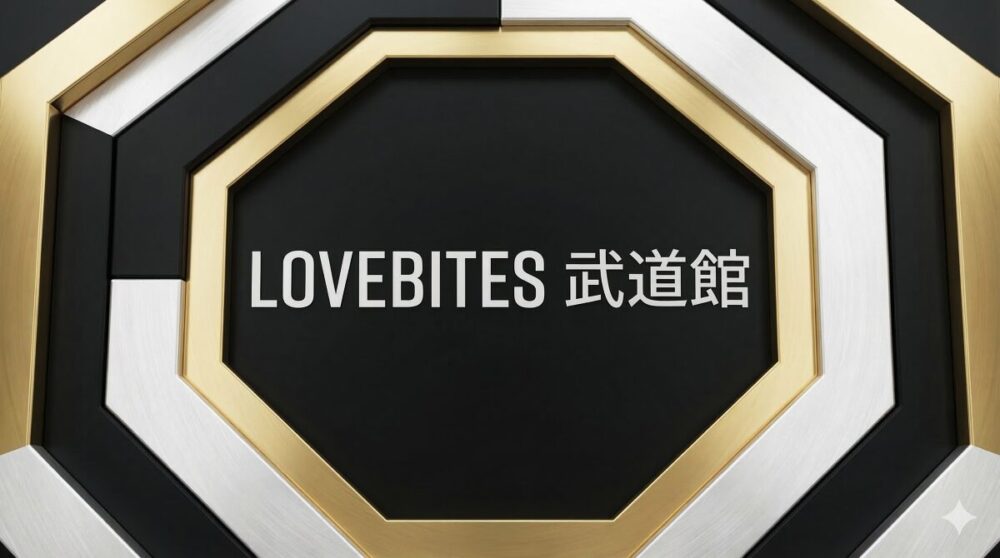 武道館の八角形をモチーフにした幾何学的なグラフィックデザイン。黒、白、金の金属的な質感の層が重なり、中央に「LOVEBITES 武道館」という日本語と英語の白い文字がシャープに配置されている。